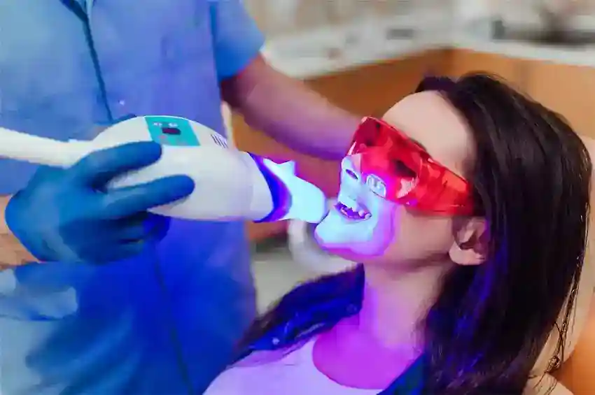 Smiling female patient undergoing Zoom Laser Teeth Whitening with dental specialist Hampshire